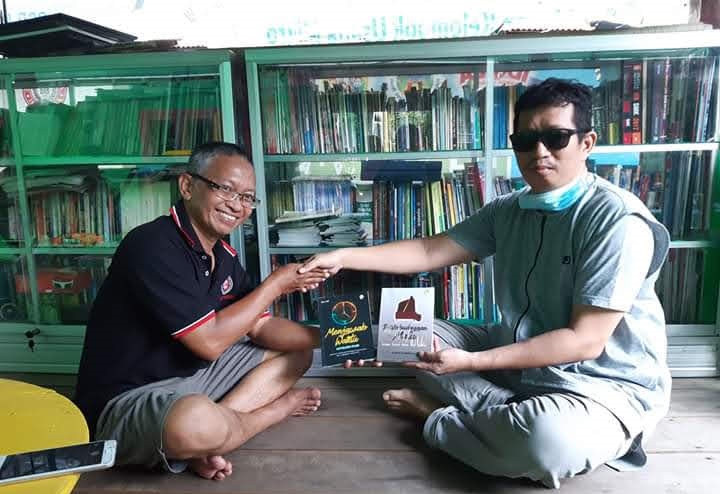 Menyerahkan buku karya sendiri kepada pengelola Rumah Baca Palontaraq di Kalabbirang, Minasatene-Pangkep. (foto: ist/*)
